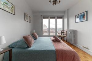 a bedroom with a large bed and a window at Le Roosevelt - Appartement confort hyper centre - Idéal Curiste in Vichy