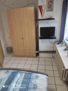 a living room with a television and a cabinet at Ferienwohnung Daisy in Langerwehe