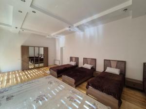 a large room with two beds and a mirror at Uyut Hostel in Ganja