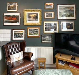 a living room with a leather chair and a television at A charming luxury apartment! in Portinscale