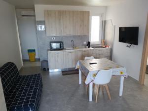 a kitchen with a table and chairs and a tv at Casa vasto via croci in Marina di Montenero +7 photos