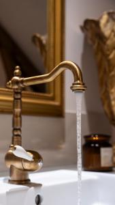 a bathroom sink with water coming out of a faucet at Dépendance maison bourgeoise in Grand-Fougeray