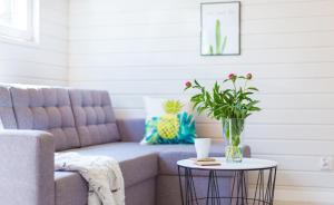 a living room with a couch and a table with a vase at Domki Acapulco nad morzem Rewal in Rewal