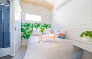 a small bedroom with a bed and a table at Domki Acapulco nad morzem Rewal in Rewal