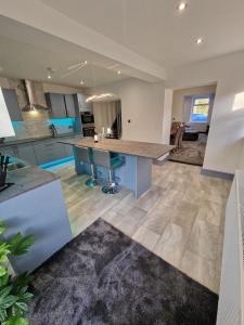 a kitchen with a large island in the middle at Stunning Modern Riverside Cottage in Aberdulais