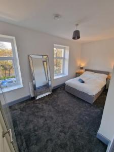 a bedroom with a bed and a mirror in it at Stunning Modern Riverside Cottage in Aberdulais