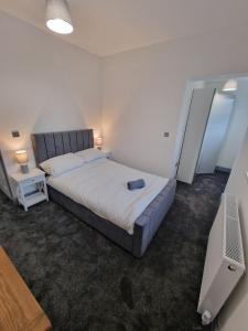 a bedroom with a large bed and a television at Stunning Modern Riverside Cottage in Aberdulais +25 photos