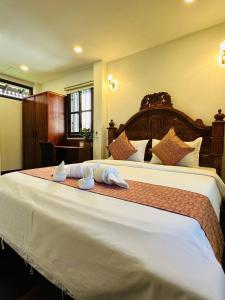 a bedroom with a large bed with towels on it at Roya Khmer Homestay in Siem Reap