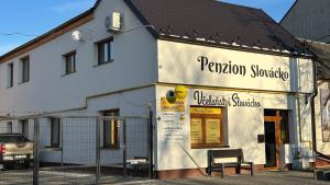 a white building with a sign on the side of it at Penzion Slovácko 2 in Ostrožská Nová Ves