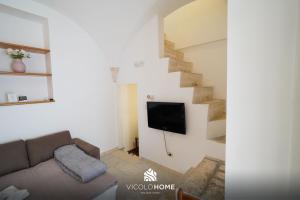 a living room with a couch and a staircase at Vicolo Home in Putignano