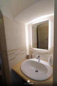 a bathroom with a white sink and a mirror at Vicolo Home in Putignano +35 photos