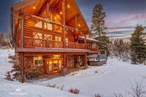 a log cabin in the snow with a grill at 8992 STINGER DR DAVENPORT in Wanship