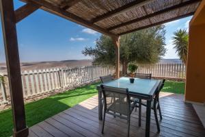 阿拉德Adi in the desert的露台上有一张桌子和几把椅子