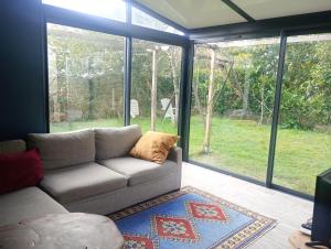 a living room with a couch in front of a window at La KLEMALINE in Pessac