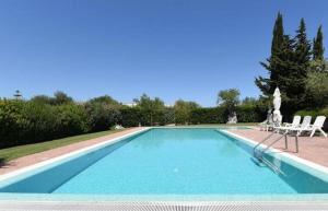 ein großer Pool mit zwei Gartenstühlen in der Unterkunft Casa Leralora - Elegante villa con piscina, a due passi dal mare in Conversano