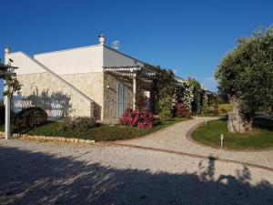 ein Haus mit einem Gehweg davor in der Unterkunft Casa Leralora - Elegante villa con piscina, a due passi dal mare in Conversano