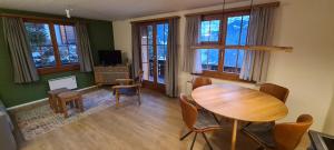 a living room with a wooden table and chairs at Chalet am Bluemewäg 7 in Wengen