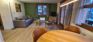 a living room with a couch and a table at Chalet am Bluemewäg 7 in Wengen