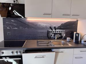 a kitchen counter with a sink and a picture on the wall at Chalet am Bluemewäg 7 in Wengen