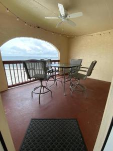 een terras met een tafel en stoelen op een balkon bij Bienvenue condo in Navarre