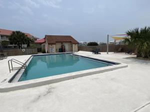 een zwembad in een tuin met een huis bij Bienvenue condo in Navarre +14 foto's