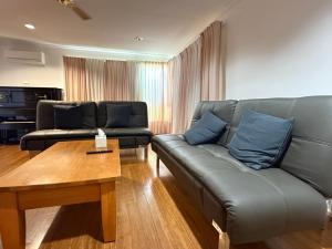 a living room with a couch and a coffee table at Hawker 4BR House in Canberra