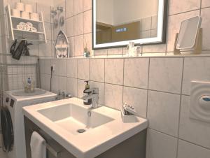 a white bathroom with a sink and a mirror at 5 Personen, familienfreundlich, Waschmaschine, Balkon, Amazon Prime in Magdeburg +20 photos