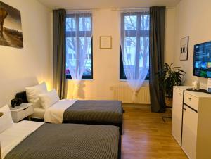 a hotel room with two beds and a television at 5 Personen, familienfreundlich, Waschmaschine, Balkon, Amazon Prime in Magdeburg