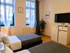 a hotel room with two beds and a flat screen tv at 5 Personen, familienfreundlich, Waschmaschine, Balkon, Amazon Prime in Magdeburg