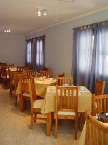 jadalnia ze stołami, krzesłami i zasłonami w obiekcie Muras Apart Hotel w mieście Mendoza