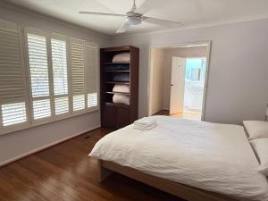 a bedroom with a bed and a ceiling fan at Hawker 4BR House in Canberra +33 photos