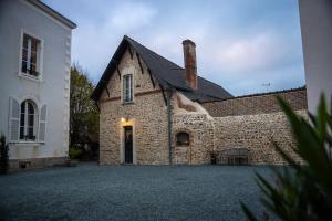 an old stone building with a chimney on it at Dépendance maison bourgeoise in Grand-Fougeray