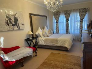 ein Schlafzimmer mit einem Bett und einem Kronleuchter in der Unterkunft At 25 Cottage 1 bedroom Balkfontein in Bothaville