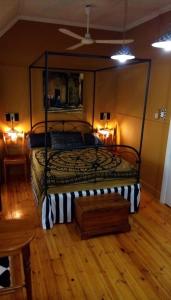 a bedroom with a bed with a metal frame at Hidden Dragon Guest Rooms in Swellendam