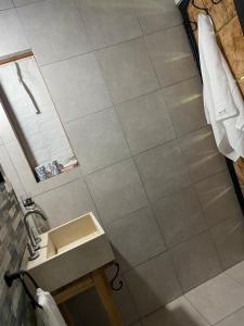 a bathroom with a sink and a tile wall at Coruya Wild in Santa Ana +7 photos
