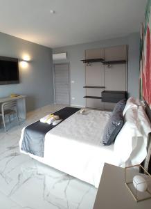 a bedroom with a large white bed and a table at Luxury Melo Apartment in Bari