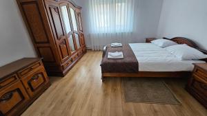 una camera da letto con un letto grande e un armadio in legno di Casa Dacian 1 a Oradea