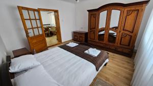 una camera da letto con un letto grande e un armadio in legno di Casa Dacian 1 a Oradea