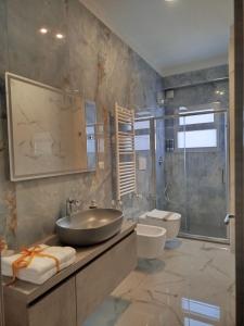 a bathroom with a sink and a toilet and a shower at Luxury Melo Apartment in Bari +18 photos