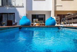 a swimming pool with blue vases on the edge of it at Perle Di Gio in Larnaca
