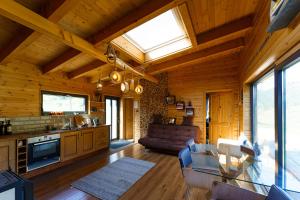 a kitchen and living room in a log cabin at Panoramic Cabin Stânceni in Ciobotani