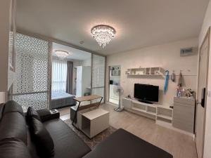 a living room with a couch and a television at DCondo Hyde near Central Plaza with Pool and Gym in Ban San Ton Ko (1)