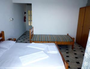 a room with two beds and two benches in it at Manthos in Kalloni