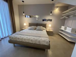 a bedroom with a bed with two lamps and shelves at Polinesia 6 in Lido delle Nazioni +25 photos