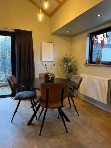 a dining room with a table and chairs at B&B de Lytse Geast in Tietjerk