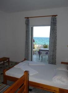 a bedroom with a bed and a view of the ocean at Manthos in Kalloni