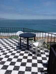 a table and chairs on a checkered floor with the ocean at Alojamiento con vista al mar in Viña del Mar