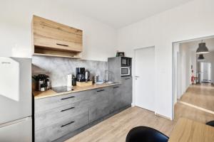 a kitchen with white walls and wooden cabinets at nobilis Apartment-6Pers-Zentrumsnah-Parkplatz-Netflix-Monteursgerecht in Meppen