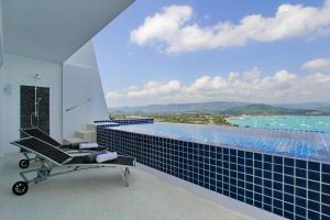 a room with a chair and a swimming pool at Luxury villa, Seaview, Private Pool in Plai Laem