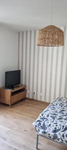 Un dormitorio con una cama y un televisor sobre una cómoda. en Studio Praga, en Varsovia